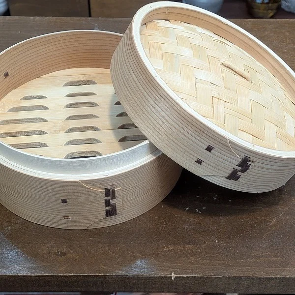 こちらは杉浦陶器店の人気商品、「せいろ（蒸篭）」です。
自然素材を活かした伝統的な蒸し道具として取り扱われています。
天然杉の香りとぬくもりを感じる、手作りの二段せいろ。
蒸気がやさしく食材を包み込み、素材の旨みをしっかり引き出します。
野菜はもちろん、肉まん・シュウマイ・おこわ・茶碗蒸しなど、多彩な蒸し料理にぴったり。
木目の美しさと竹編みの蓋が食卓にもよく映え、調理後そのまま器として使えるのも魅力です。
おすすめの使い方：
下段に根菜、上段に肉や魚を入れて一気に蒸し上げ。
茶碗蒸しやプリンなどのやさしい火加減が必要な料理にも。
蒸し終わったらせいろごと食卓へ。見た目も香りもごちそうです。